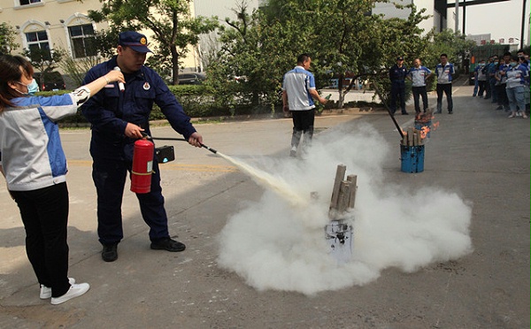 贾教官在示范灭火器的正确使用方法